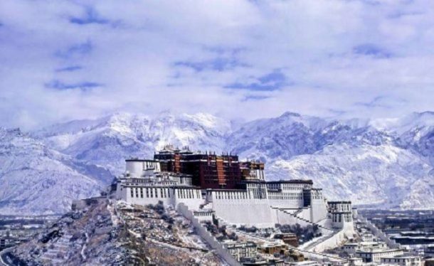 A light dusting of snow coats the Potala Palace while the mountains behind are covered in thick snowfall