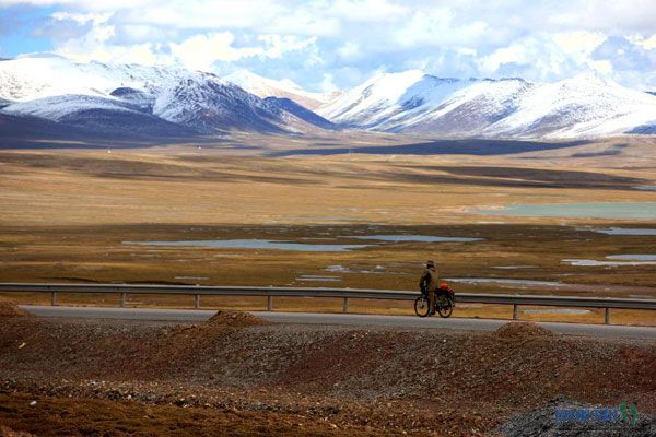 A cyclist stops to enjoy the scenery on the Tanggula Shankou section of the Qinghai-Tibet Highway