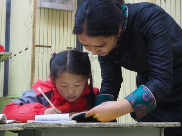 A teacher instructing a student at the Lawugan Village primary school in Yushu Tibetan Autonomous Prefecture
